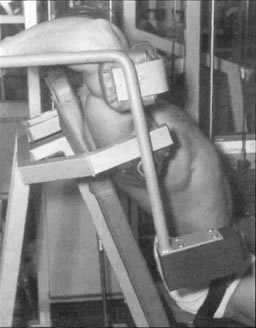 Атлет выполняет пуловер в тренажёре. Однако данная исходная позиция травмоопасна из-за слишком большой амплитуды движения. Обратите внимание но опасный выгиб в пояснице.